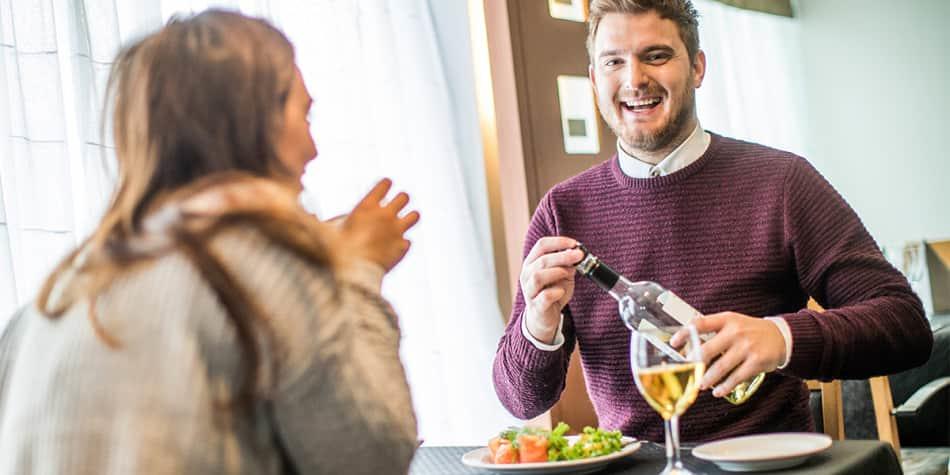 Paar sitzt im Restaurant und trinkt Weißwein
