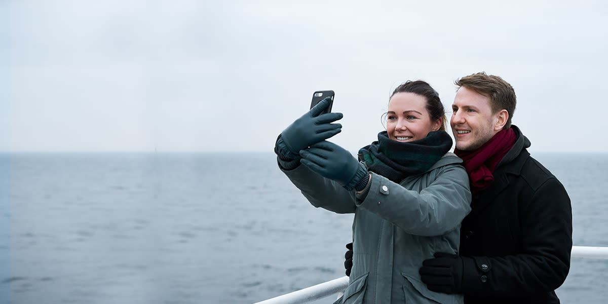 Couple taking selfie on deck Couple taking selfie on deck - Hero