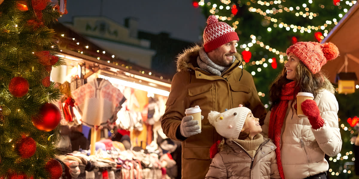 Familie mit Getränken auf einem Weihnachtsmarkt XMAS Markets General HERO
