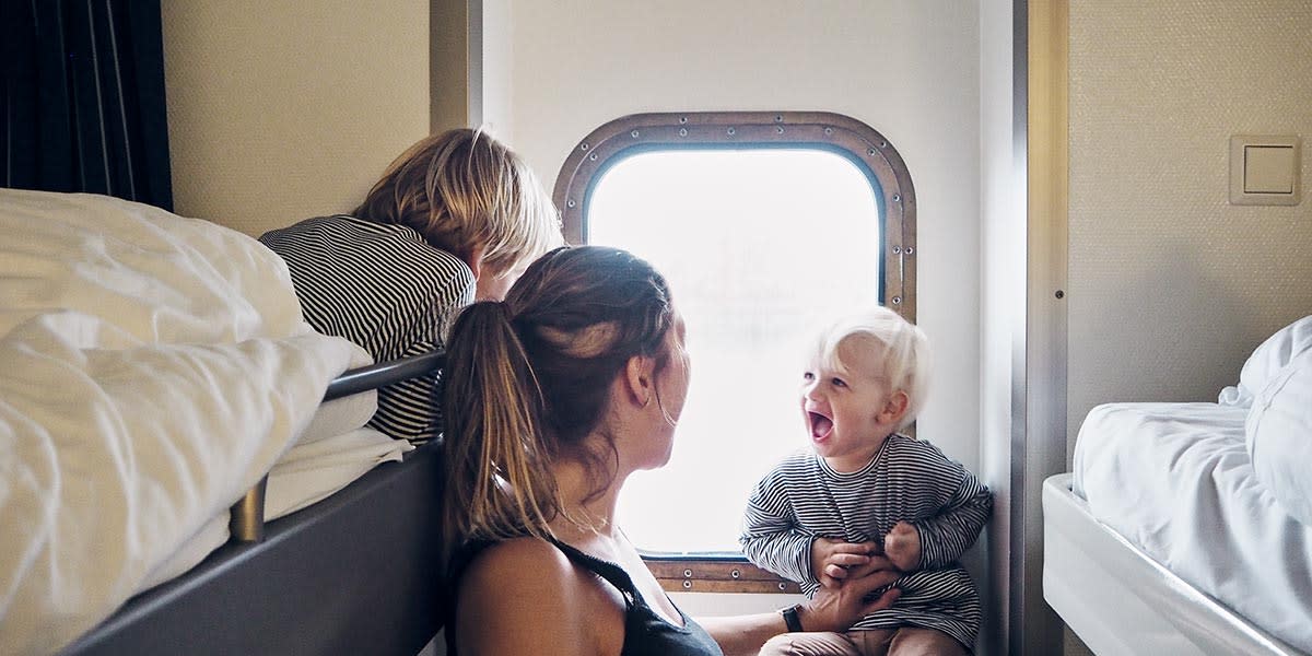 En familie griner sammen i en kahyt med havudsigt Kahyt med havudsigt ombord Newcastle-Amsterdam